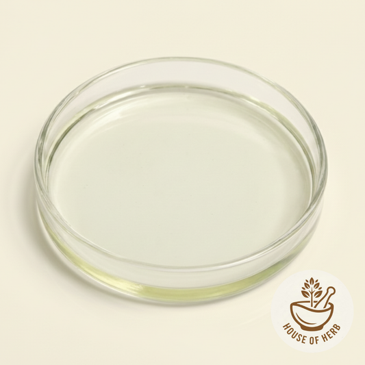 Clear glass bowl with basil seed Oil on a beige background with 'House of Herb' logo.